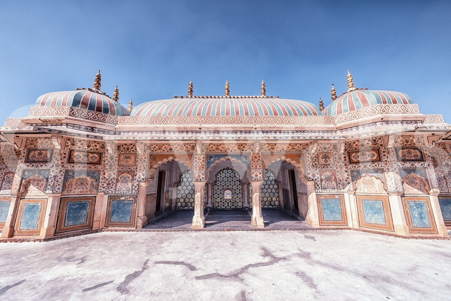 Jaipur Jewel wall mural with painted palace facade, domes, and open blue sky above