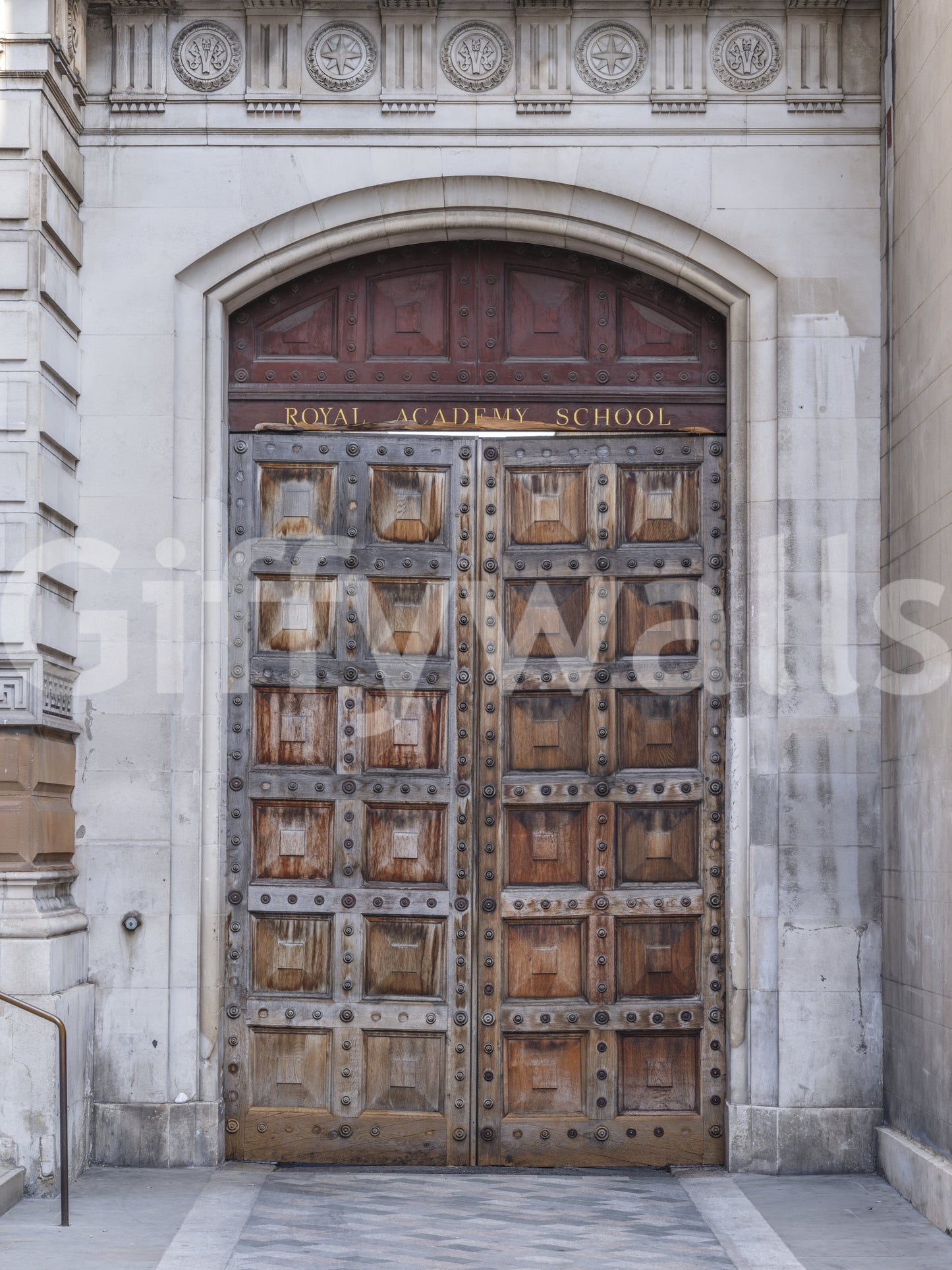Historic academy portal wall mural with grand wooden double doors and stone arch., GD10463