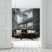 Black-and-white mural of Manhattan Bridge with urban skyline.

