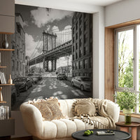Cityscape mural of Manhattan Bridge with dramatic sky.

