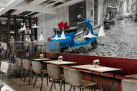 The scene is set on a narrow, European street.

