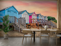 A wall mural of a peaceful beach scene with pastel beach huts.

