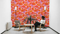 The mural is installed in a cheerful living room behind a simple, light-colored sofa.

