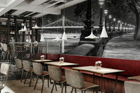 A row of ornate lampposts with glowing lights lines the walkway.

