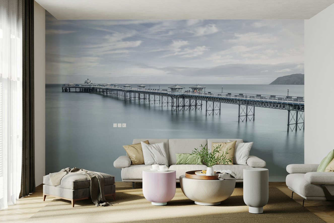 A peaceful wall mural with a long pier stretching into the sea.

