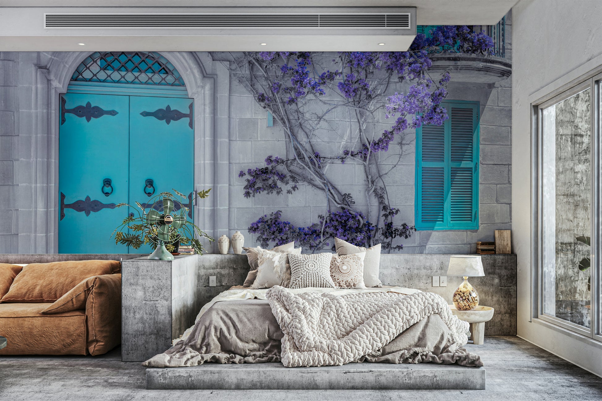 A purple flowering plant climbs the stone wall.

