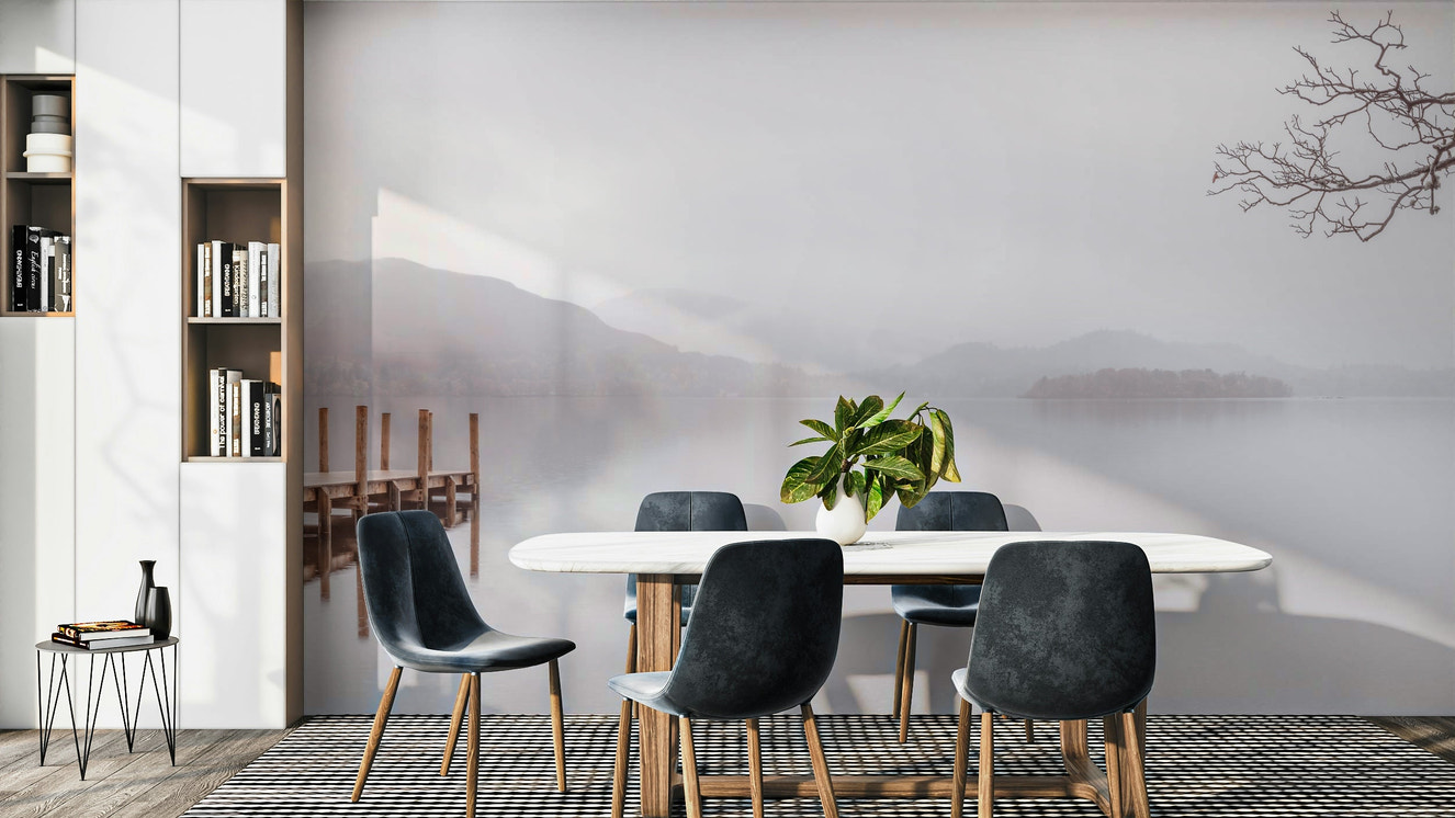 A beautiful serene lake with misty mountains in the background.

