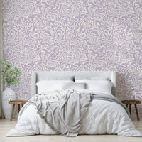 The pink swirls wallpaper applied to a wall behind a bed.

