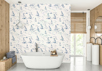 A bathroom decorated with sailboat wallpaper

