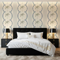 A bedroom welcomes calm vibes from sage palm trees on this slate blue wallpaper.