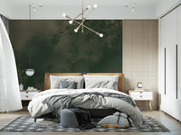 Moody forest wall mural behind a bedroom in deep green and olive tones