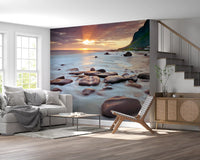 Sun rays cast over rocky shore on this coastal sunset serenity wall mural.