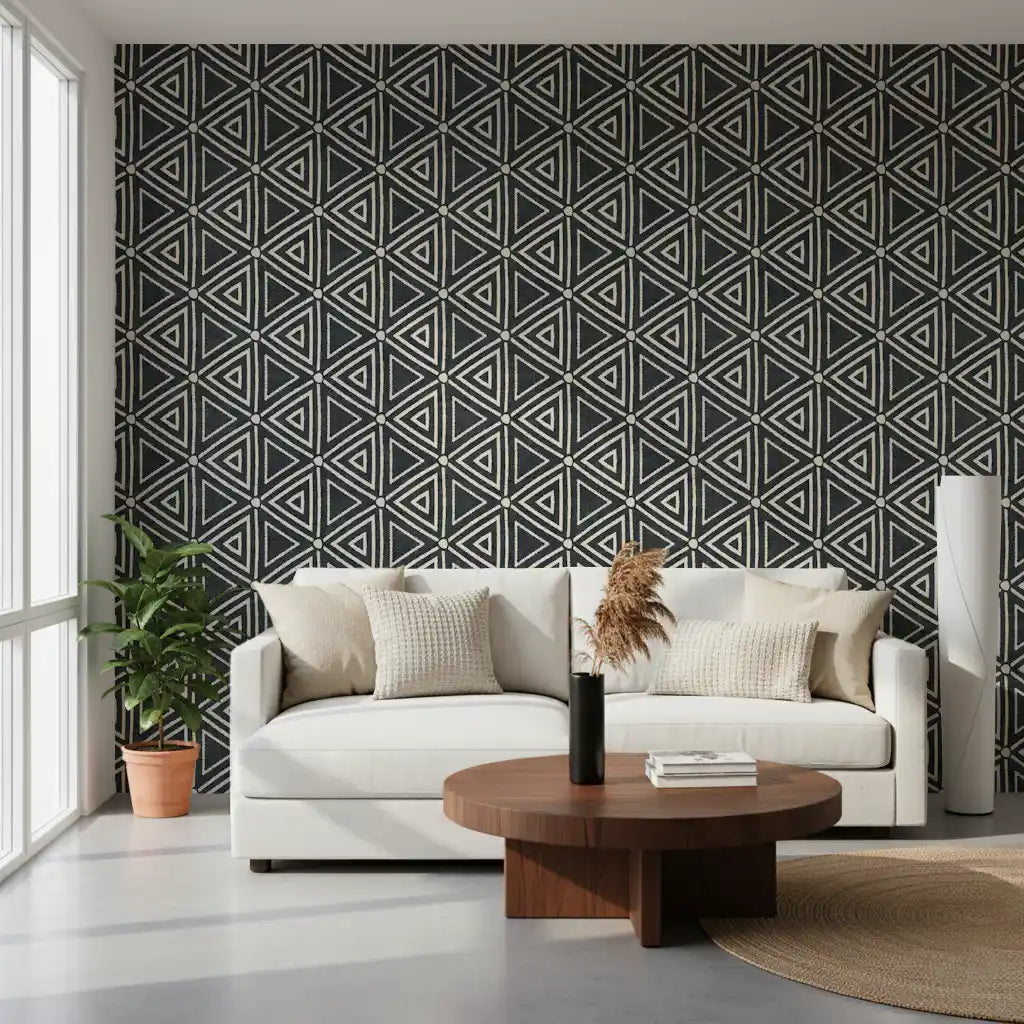 Charcoal mudcloth wallpaper grounds a cosy living room with bold cream triangle pattern.