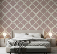 Dusty rose lattice trellis wallpaper on an accent wall in a bedroom setting.