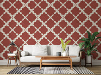 Geometric trellis wallpaper on a living room wall in rust red and cream.