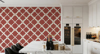 Geometric repeat trellis wallpaper on a dining room wall in rust and off-white 
