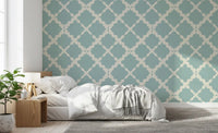 Dusty teal lattice pattern wallpaper as a feature wall in a bedroom setting.