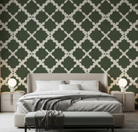 Moss green lattice trellis wallpaper on an accent wall in a bedroom setting.