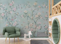 Chinoiserie aviary wall mural in nursery with soft teal and pastel floral tones.