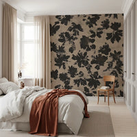 Bedroom accent wall featuring black botanical silhouette mural on warm beige.