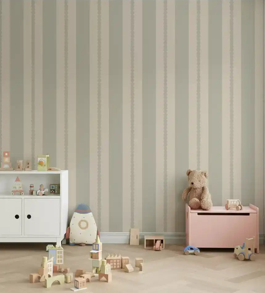 Nursery wall with neutral scallop stripe wallpaper in a muted palette.