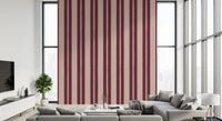 Living room interior wall with bold scallop stripe wallpaper in berry and blush.