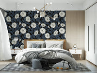 Bedroom wallpaper with large white floral motifs and dark blue shaded leaves.