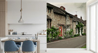 Dining area wall mural of a traditional stone cottage and white flowers.