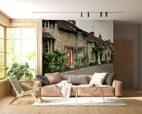 Living room wall mural featuring a historic village street and stone house.