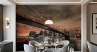 Large cityscape wall mural featuring a steel suspension bridge and tall buildings.