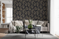 Dark botanical wallpaper with beige branch illustrations in bright living room.