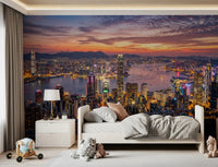 Twilight sunset wall mural with glowing city lights and mountain background.