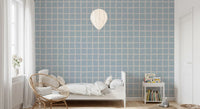 Kids bedroom with rattan chair and ceramic vase set against soft blue Boho Coastal Grid wallpaper., GD9913
