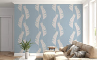 Banana leaves wallpaper covering the walls of a brightly sunlit living room., GD9917
