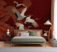 The graceful flight of four cranes captured on a red textured wall mural.