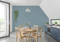 Calm dusty blue wallpaper lines the walls of a spacious dining room.