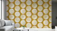Geometric wallpaper displaying cream dots with gold speckled fill against mustard surface.