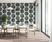 Geometric polka dot wallpaper with dark blue circles on neutral cream tone in dining area.