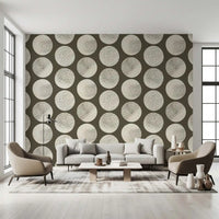 Repeated cream polka dots with stippled surfaces create rhythm on brown wallpaper.