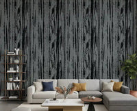 Charcoal grey woodgrain wallpaper with vertical organic lines and textured surface in living room.