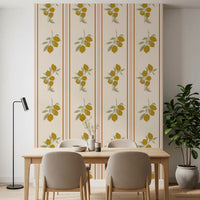 Dining corner with a small round table and rattan chairs sitting in front of olive lemon branch wallpaper.