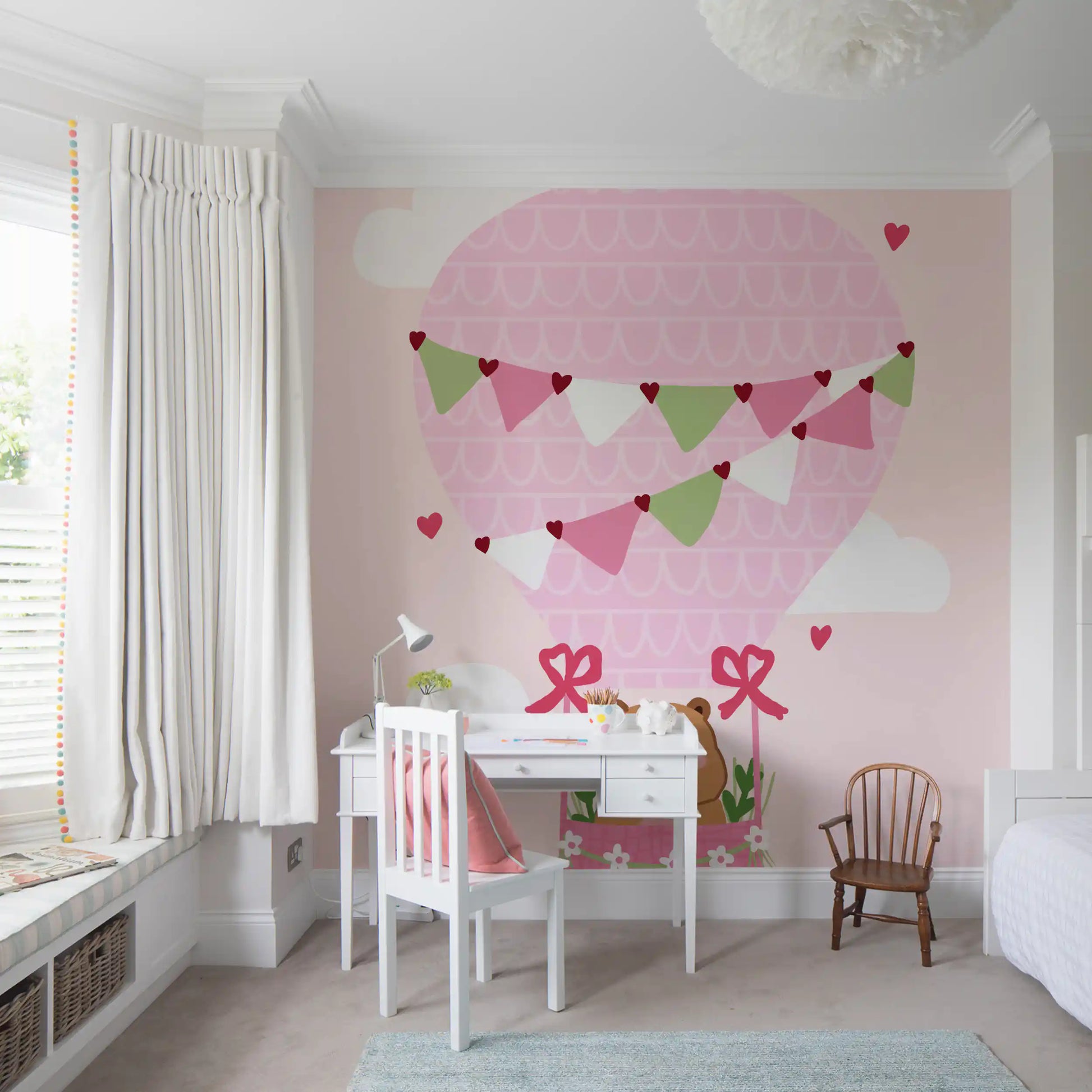 Heart bunting in pink and sage green across cartoon balloon mural in study room.
