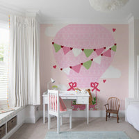 Heart bunting in pink and sage green across cartoon balloon mural in study room.