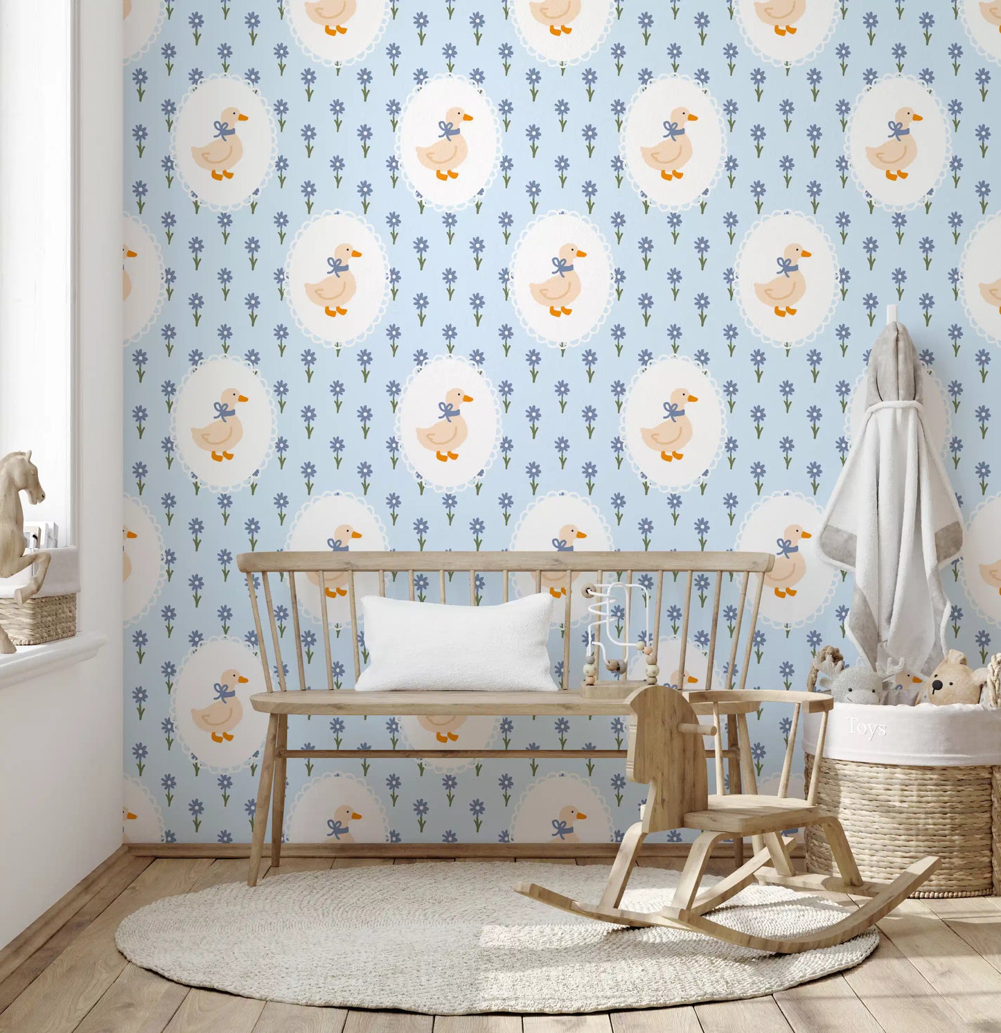 Cream goose tied wallpaper with blue ribbon inside a white scalloped oval frame