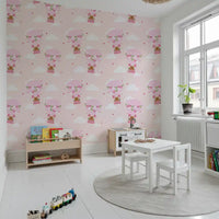 Nursery wallpaper with bear balloon motif in pastel pink tones.