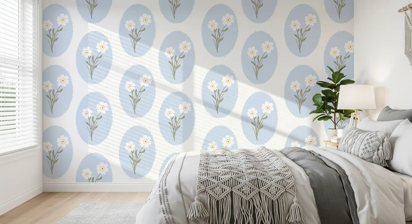 Bedroom wall featuring scalloped floral wallpaper with white daisies and blue oval frames.