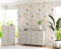 cottage wallpaper with thatched roofs, climbing stems, and scattered daisy heads.
