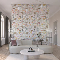 Playful cottage wallpaper holding mustard, coral, and slate florals on a white ground.