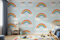 Bedroom corner with rainbow wallpaper and pastel cloud pattern.