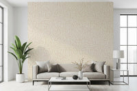 Beige wallpaper with cream brushstroke arcs scattered across a soft painted base. 